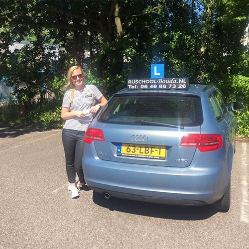 Geslaagde leerling naast de Bouda-lesauto
